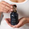 A woman opening a bottle of MyPause Women's B Energy Complex.