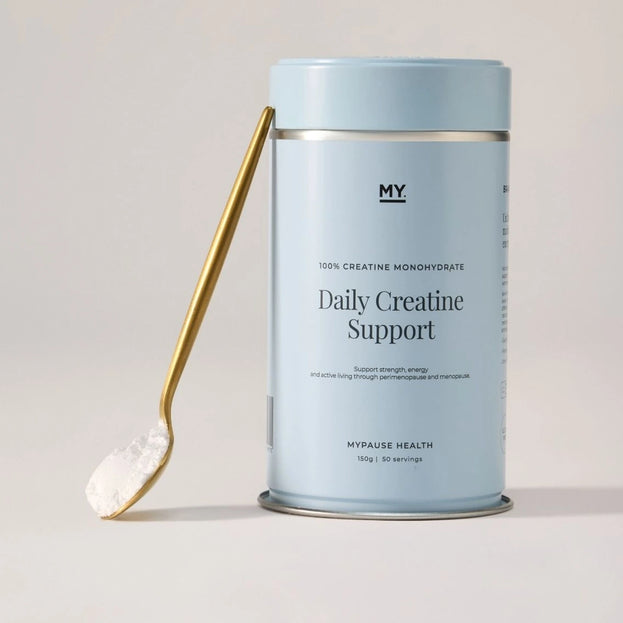 Daily Creatine Support tin with a scoop of powder on a gold spoon.