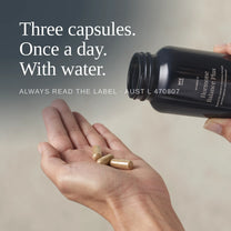 Three Hormone Balance Plus capsules poured into an open hand: three capsules, once a day, with water.