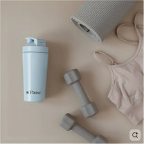 The MyPause steel shaker bottle in a flat lay with dumbbells, a rolled yoga mat and a sports bra.