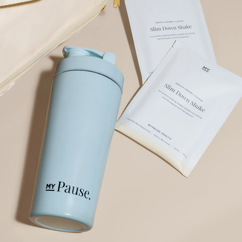 The MyPause steel shaker bottle lying beside MyPause product packaging on cream linen.